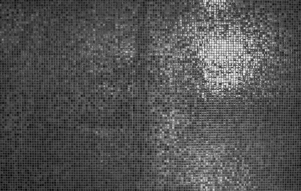 A detailed grayscale mosaic texture with reflective highlights, perfect for modern design backgrounds.